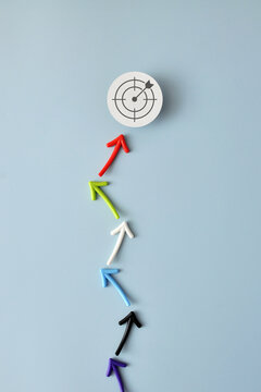 Colorful arrows reaching target representing strategic planning and business success