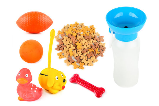 Collection of pet toys, treats, and portable water dispenser isolated on white background. Colorful dog accessories flat lay featuring bone-shaped treats and rubber squeak toys.