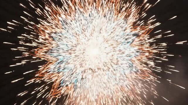 Vibrant cyan and orange firework mandala display in time lapse at night