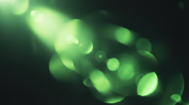 Abstract green light flare effect on dark background