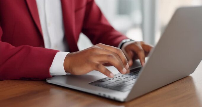 Professional man wearing red jacket typing on laptop