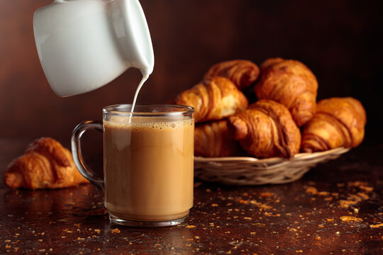 Coffee latte and croissants on a brown background.