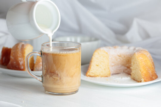 Cream is poured into a coffee mug.