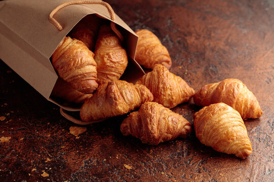 Fresh croissants on a brown vintage table.