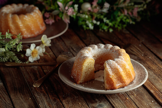 Easter cakes and spring flowers on an old wooden table.