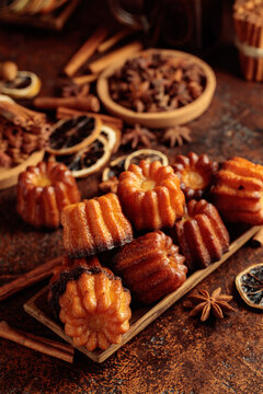 Cinnamon cakes in wooden dish on a brown background.