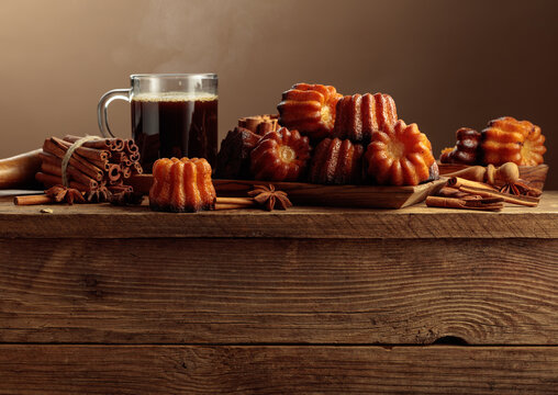Cinnamon cakes and black coffee on an old wooden table.