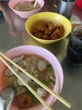 noodle soup. Thai noodle soup. Thai food. Asian food. Braised beef. Frish meatballs. Noodles. Hot broth. Chopsticks. Homemade food. Bowl of noodles. Comfort food.
