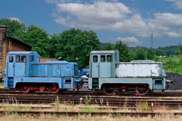 Fototapeta premium Two vintage blue diesel shunting locomotives parked on outdoor railway tracks