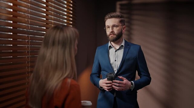 Actor and producer talking in film agency. Casting director conducting audition for role in movie. Male actor holding coffee and talking to film producer. Man passing casting for main role.