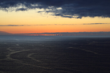 Fototapeta premium Dramatic sunset over the Atlantic Ocean beneath massive storm clouds