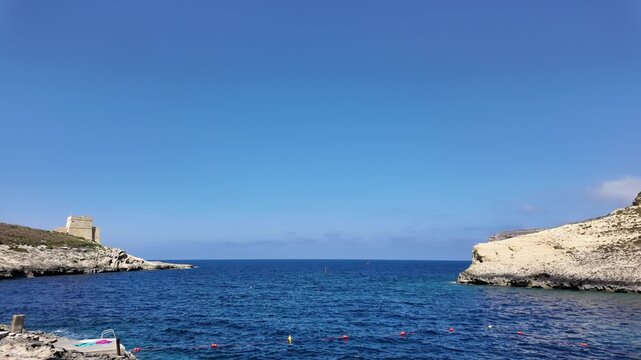 Rugged coastline, and calm sea in a sunny day in Xlendi bay, Munxar, Gozo,Malta. High quality 4k footage