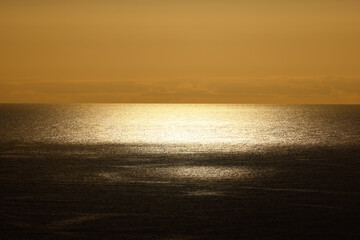 Golden sunset over the Atlantic Ocean beneath dramatic storm clouds © Gabriela