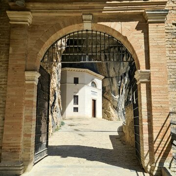 Tempietto del Valadier, Genga, Marche, Italy. View through an old arched gate toward the historic cave chapel near Frasassi Gorge.