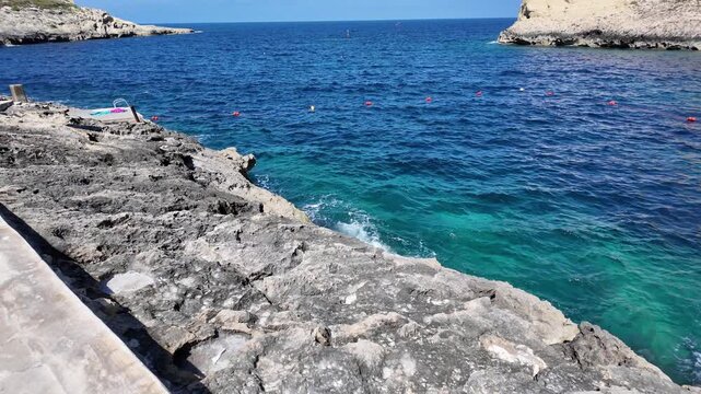 Rugged coastline, and calm sea in a sunny day in Xlendi bay, Munxar, Gozo,Malta. High quality 4k footage