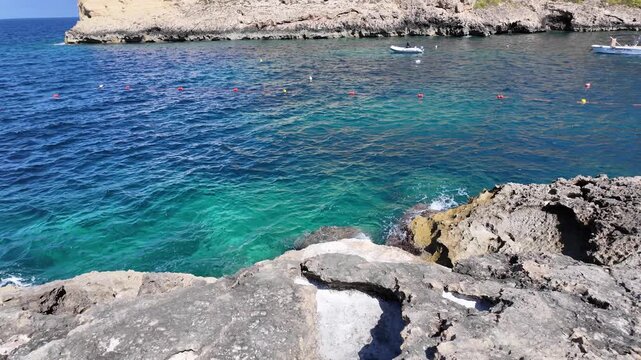 Rugged coastline, salt and calm sea in a sunny day in Xlendi bay, Munxar, Gozo,Malta. High quality 4k footage