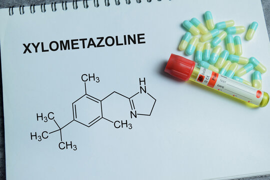 Concept of xylometazoline nasal decongestant write on book isolated on Wooden Table. For relief or nasal congestion and sinus treatment