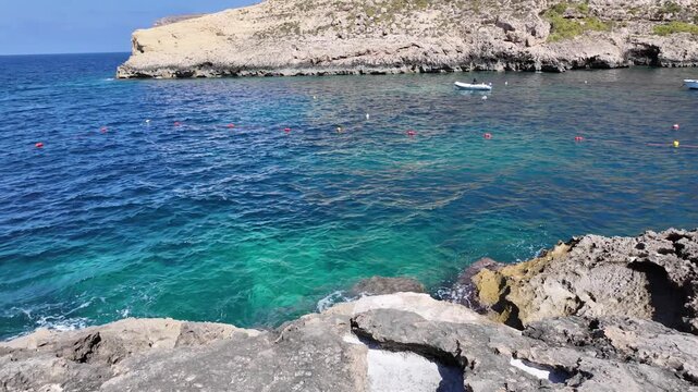 Rugged coastline, salt and calm sea in a sunny day in Xlendi bay, Munxar, Gozo,Malta. High quality 4k footage