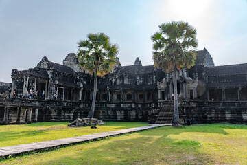 Obraz premium Ancient Khmer Temple Courtyard with Palm Trees in Cambodia