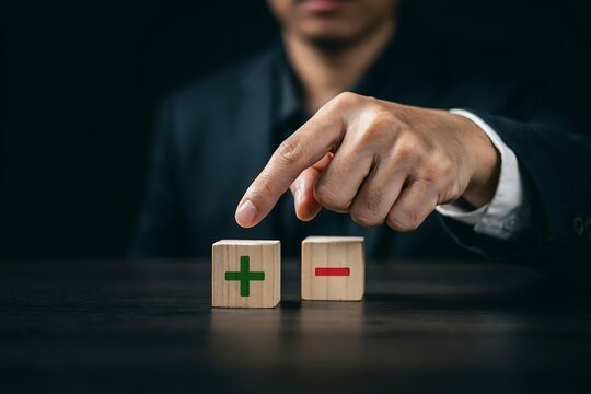 Businessman choosing between a positive plus and negative minus sign on wooden toy blocks