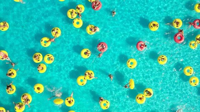 Top view - young people relax in swimming pool at bubble bath.	