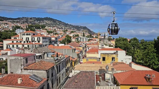 Funchal Cable Car cabin over historic Old Town rooftops with the Atlantic Ocean, Madeira, Portugal