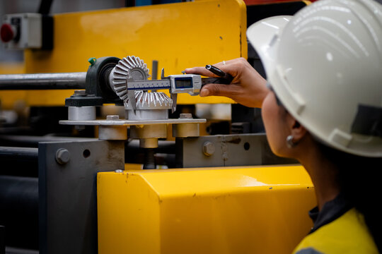 Female industrial engineer. Industrial quality inspection. Female factory worker checking production line equipment in a manufacturing plant. Factory, inspection, manufacturing, engineer, safety.
