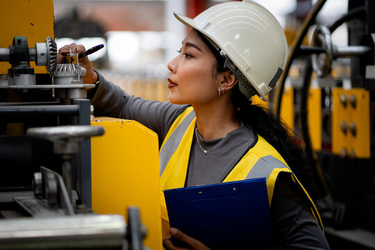 Female industrial engineer. Industrial quality inspection. Female factory worker checking production line equipment in a manufacturing plant. Factory, inspection, manufacturing, engineer, safety.
