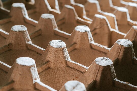 Cardboard egg carton tray texture as pattern. Recycled ecological material for food packaging. Sustainable waste management and pulp product industry concept. Macro close up background.
