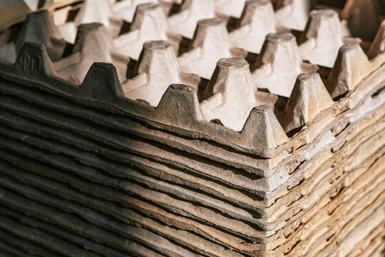 Stack of cardboard egg cartons. Recyclable material for packaging storage. Sustainable paper product for wholesale industry. Eco friendly material for environmental conservation concept.