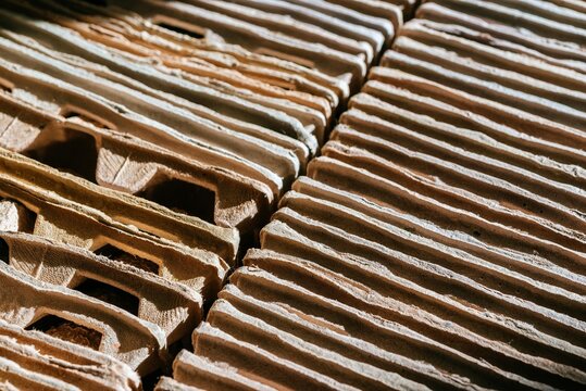 Stack of recycled cardboard egg trays arranged in rows. Sustainable material and eco friendly packaging concept. Paper waste product for industrial sorting and environmental protection.