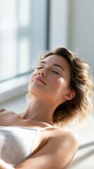Naklejka premium Calm bright portrait of woman lying near window with relaxed expression for skincare wellness banner and beauty design