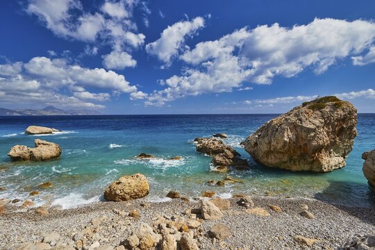 Stony coast with large rocks in the foreground and clear sea under clouds, Kato Lakkos Beach, still almost untouched bay, not accessible by car, Kato Lakkos, East Coast, Karpathos, Dodecanese, Greek Islands, Greece