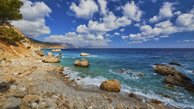 Quiet beach with large rocks framed by deep blue water and a wide sky, Kato Lakkos Beach, still almost unspoilt bay, not accessible by car, Kato Lakkos, East Coast, Karpathos, Dodecanese, Greek Islands, Greece