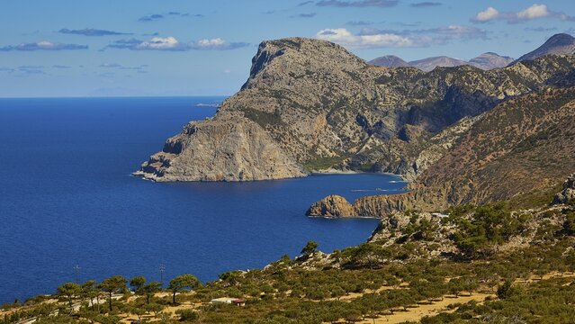 Rocky coastal landscape above a deep blue sea under a clear sky, Mesochori village, west coast, Karpathos, Dodecanese, Greek Islands, Greece