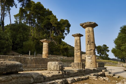 Temple of Hera, Heraion, Three preserved pillars in a historic site with a wooded background, Archaeological Site, Ancient Olympia, Olympia, Peloponnese, Greece