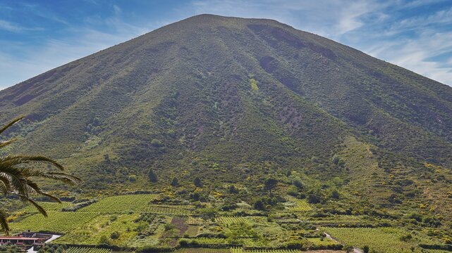 Green volcanic mountain, Monte dei Porri, vineyards, fields, sky exchanged, Valdichiesa, Salina, Aeolian Islands, Sicily, Italy
