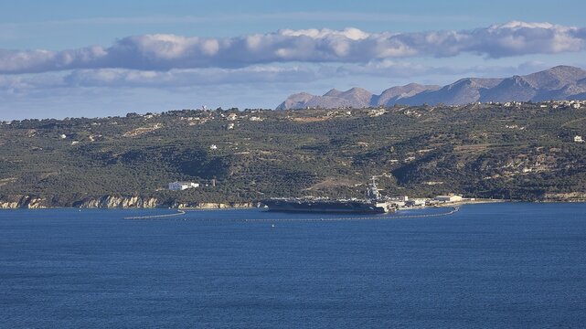 Aircraft carrier USS Gerald R. Ford, largest aircraft carrier in the world, anchored in Souda Bay on February 24, 2026, aircraft carrier off a wooded coastline with mountains, US Navy, Souda Bay, Akrotiri Peninsula, Chania Province, Crete, Greek Islands, Greece