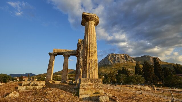 Archaic Temple of Apollo, Doric columns, Golden light falls on the ancient columns with picturesque mountains in the background, Archaeological site, Archea Korinthos, Corinth, Peloponnese, Greece
