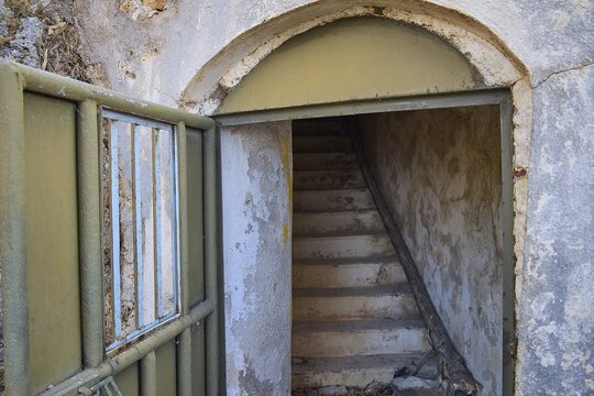 An open entrance with stairs leads into a dilapidated, secluded structure, Lost Place, Lago anti-aircraft battery, bunker, Apitiki Mountain, Leros, Dodecanese, Greek Islands, Greece