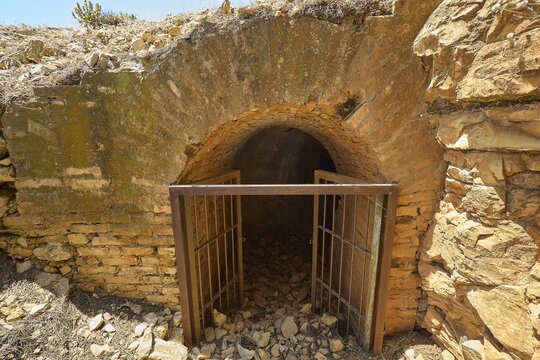 Access to a dark tunnel with a stone arch and lattice closure, Lost Place, Air Defence Position, Aerophone, Parabolic Acoustic Mirror, Patella Mountain, WW2, west of Lakki, Leros, Dodecanese, Greek Islands, Greece