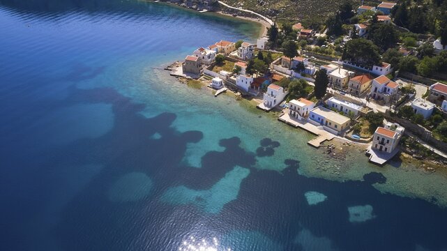 Drone shot, coastal village with white houses on the blue sea and clear coastal landscape, Bay of Emporio, Emporio, Symi, Dodecanese, Greek Islands, Greece