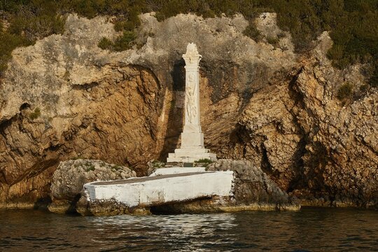 Monument to Count Santorre di Santarosa who died on May 8, 1825 in Navarino Bay defending the island of Sfaktiria, A white statue on rocky ground on the coast stands out against the natural background, morning light, islet of Tsichli Babas, island of Sfaktiria, Navarino Bay, Pylos, Peloponnese, Greece