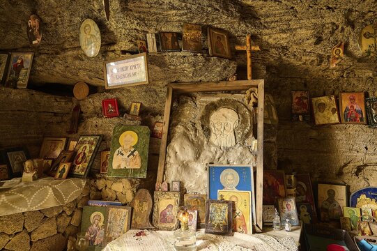 Altar area in a rock cave, surrounded by various crosses and religious symbols and icons, rock church of Agios Nikolaos, Oasis Beach, Kallithea, Rhodes, Dodecanese, Greek Islands, Greece