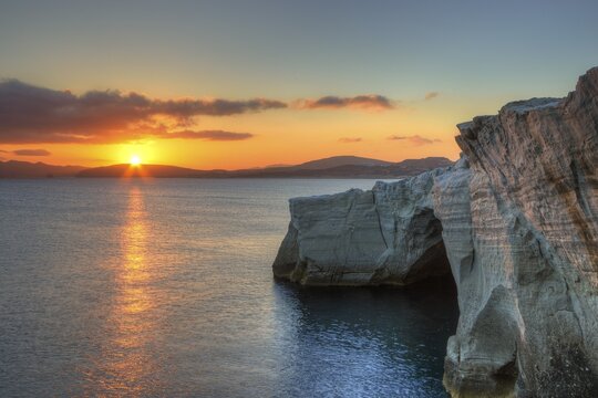 Morning light, sunrise, sun as a star, orange-red sky, tufa rock, tufa rock in the shade, Sarakiniko Beach, Milos Island, Cyclades, Greece