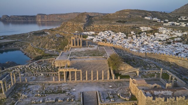 Drone shot, first morning light, Lindos, Acropolis of Lindos, Propylaea with flight of steps, Temple of Athena Lindia, Ruins of ancient columns on a cliff overlooking the sea at dusk, Archaeological site, Lindos, Rhodes, Dodecanese, Greek Islands, Greece