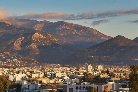 City view at sunset with mountains in background and cloudy sky, Patras, Peloponnese, Greece