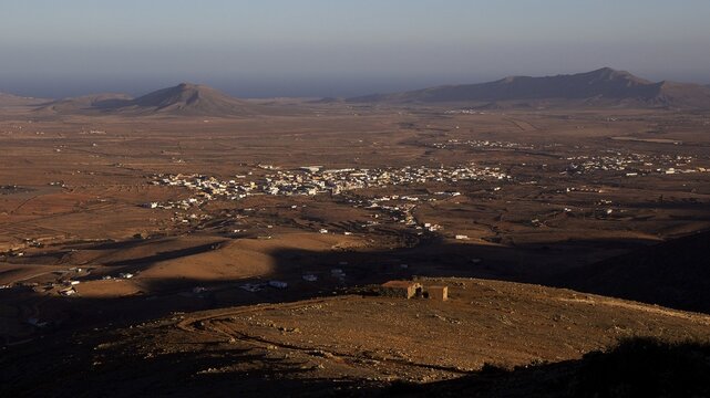 Mirador Morro Velosa, Barren hilly landscape, mountain shade, settlements, lava hills, blue cloudless sky, Fuerteventura, Canary Islands, Spain