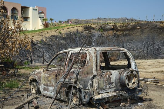 A burnt-out car stands in a destroyed landscape, destroyed trees and a building in the background, forest fires, summer 2023, forest fire damage, Boutique 5 Hotel, Kiotari, Rhodes, Rhodes, Dodecanese, Greek Islands, Greece