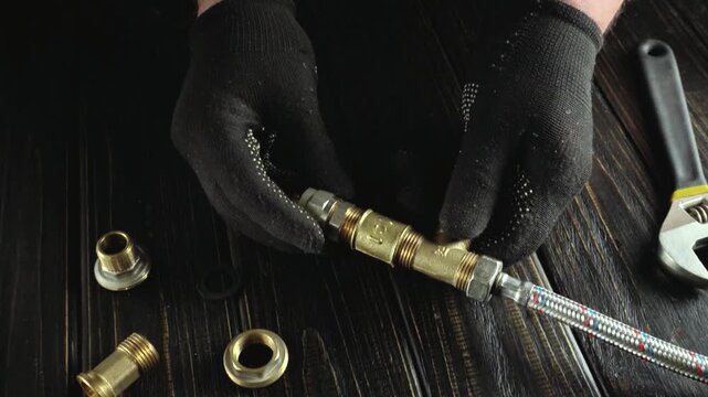 Technician assembles plumbing fittings with gloves on a wooden work surface, showcasing a sequence of precise actions and tools in use